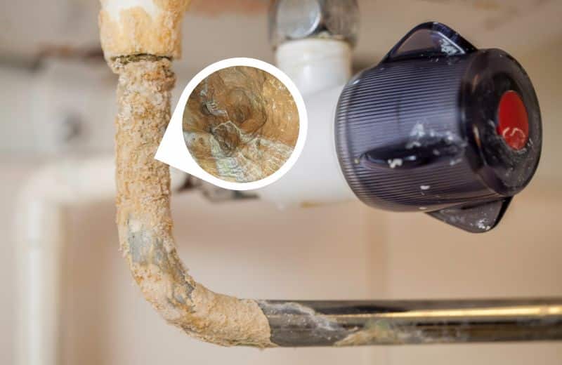 Limescale buildup on under sink pipe