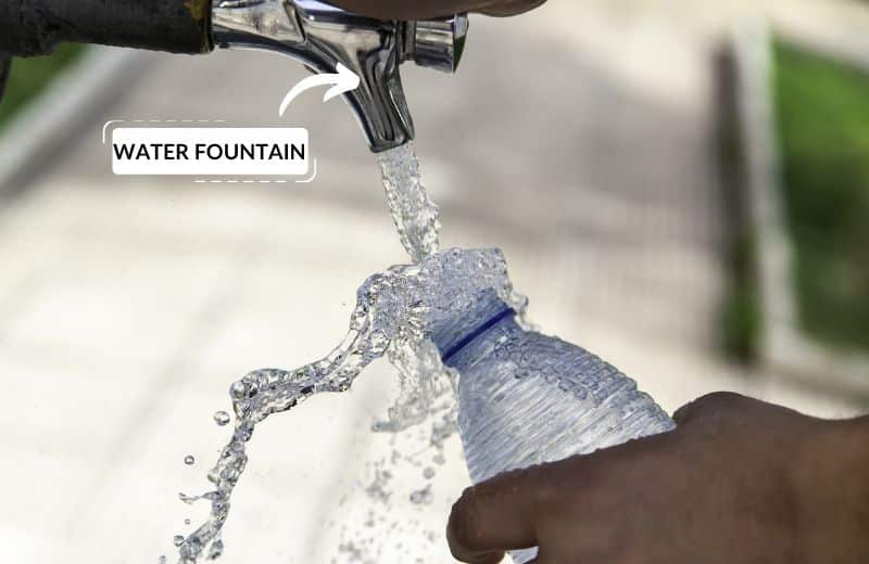 Filling plastic water bottle from public drinking fountain