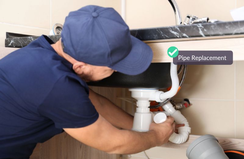 Plumber replacing under sink pipe