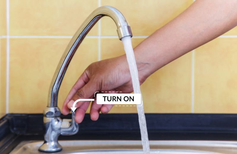 Person turning the faucet on