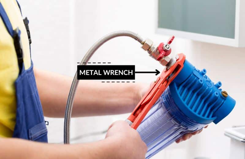 Removing a stuck water filter with a metal wrench