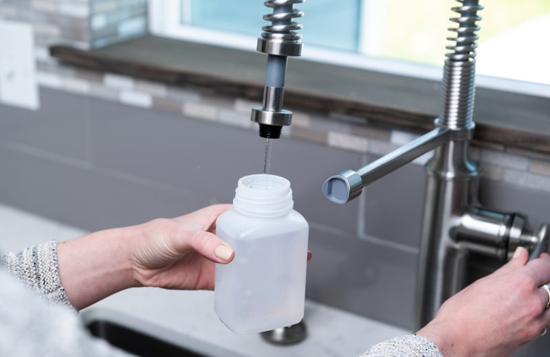 Taking a water sample from faucet for testing purposes