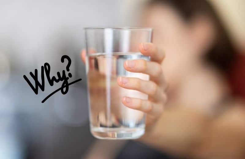 Woman holding a glass of water with text "why" next to it