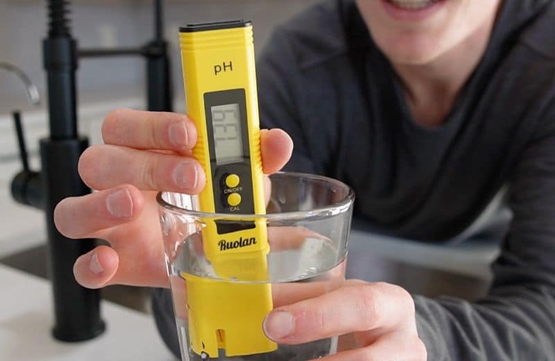 Express RO5DX pH Level Brian holding a ph meter dipped in a glass of water