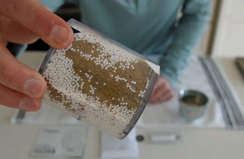 Hammerhead Shower Filter Material Hammerhead shower filter media cartridge showing layered filtration materials, including white calcium sulfite beads and brown KDF media, designed to reduce chlorine and impurities.