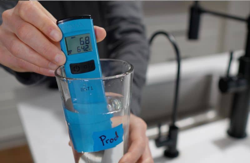 Digital TDS meter measuring Cloud RO filtered water in a glass, displaying 68 ppm total dissolved solids during performance testing.