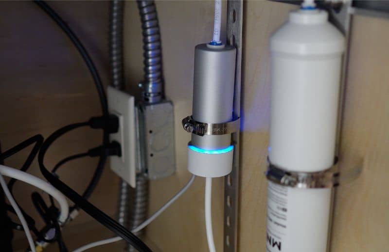 Waterdrop G3 P800 UV Waterdrop G3P800 filter under-sink installation featuring UV sterilizer with glowing blue ring, cartridge, and connected electrical components